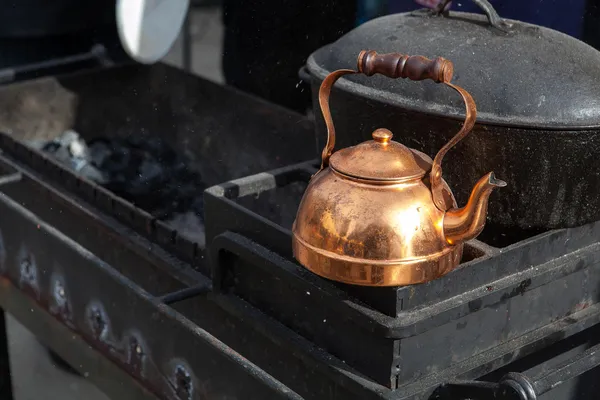 黑色烤架上的旧铜茶壶 — 图库照片