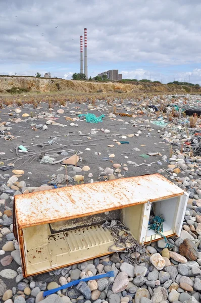 在附近一家工厂的海边上的人为破坏的冰箱 — 图库照片