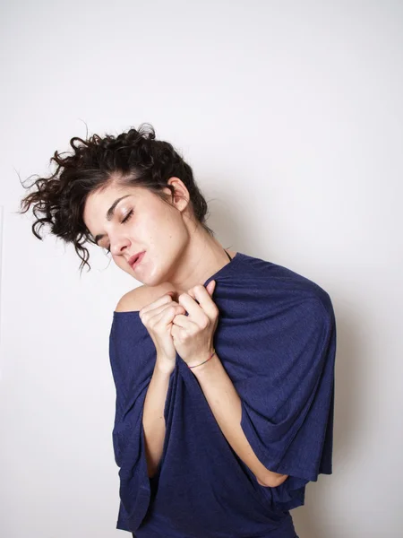 Young woman in blue t-shirt hugging herself — Stock Photo, Image