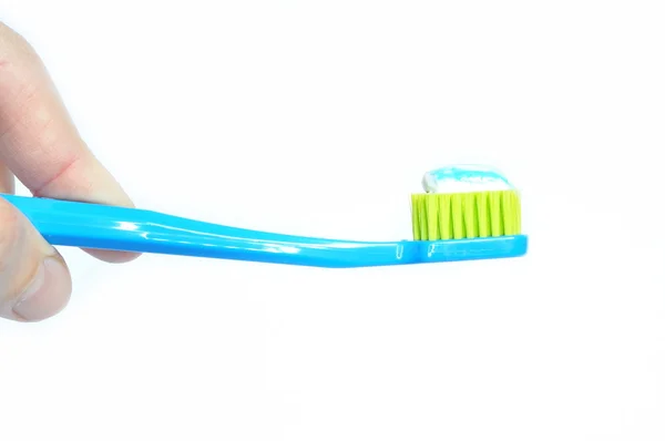 Toothbrush and toothpaste in hand, isolated — Stock Photo, Image