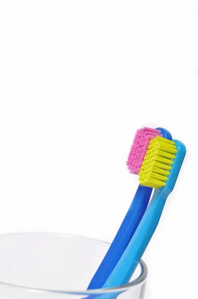 Farverige tandbørster i et glas - Stock-foto