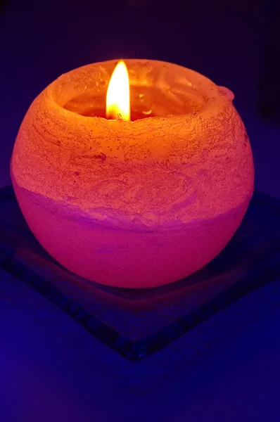 Oranžová svíčka na modrém pozadí — Stock fotografie