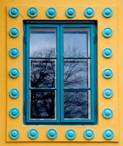 Cyan colored window on a yellow wall — Stock Photo, Image