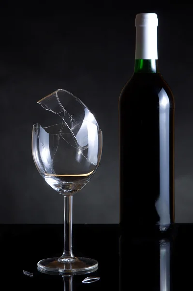 Víno láhev a střepy na tmavém pozadí — Stock fotografie