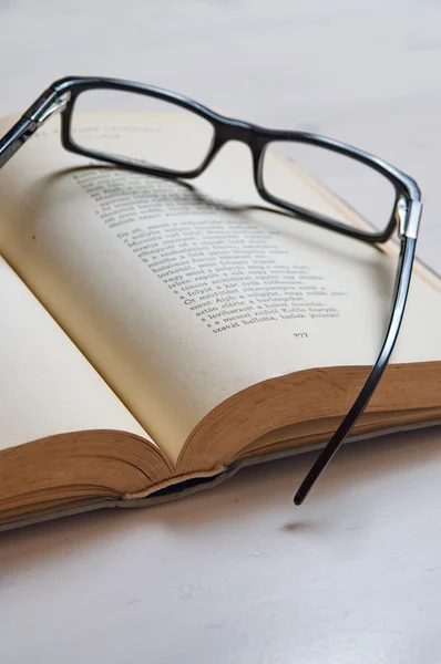 Behandlingen glas på en gammal bok — Stockfoto