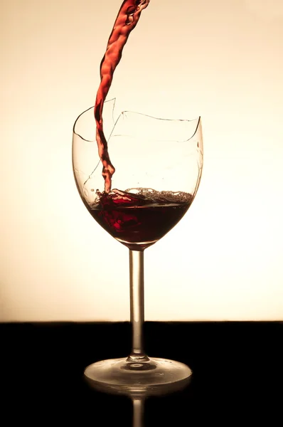 Červené víno přelijete do rozbitého skla — Stock fotografie