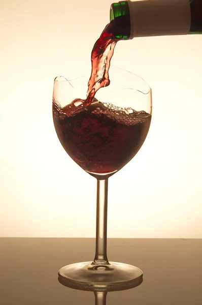 Červené víno přelijete do rozbitého skla — Stock fotografie