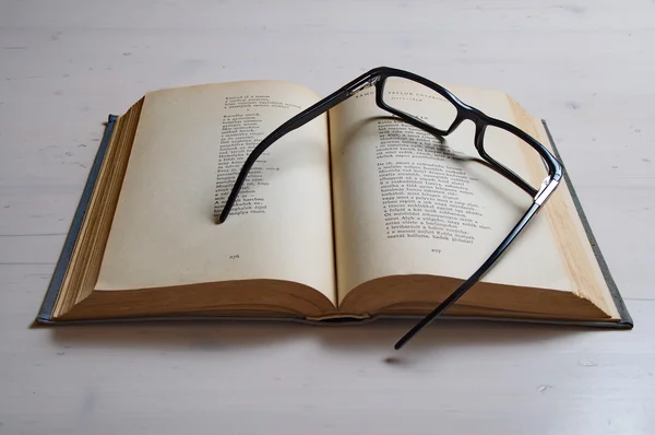 Reading glass on an old book — Stock Photo, Image