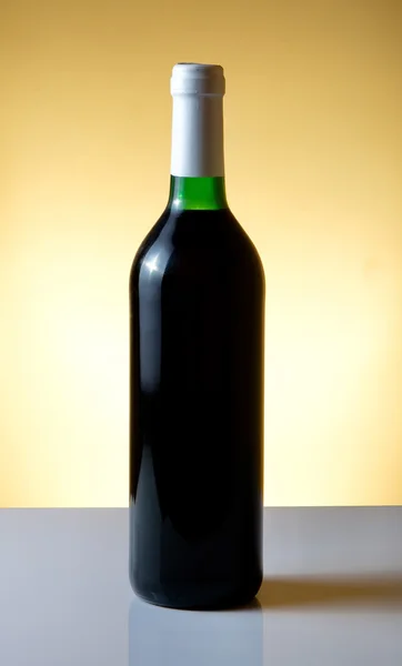 Turuncu arka planda şarap şişesi — Stok fotoğraf