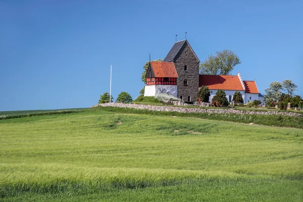 Campi verdi vicino alla chiesa di Ruts Kirke a Bornholm — Foto Stock