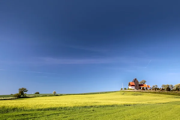 Campos verdes pela igreja Ruts Kirke em Bornholm — Fotografia de Stock