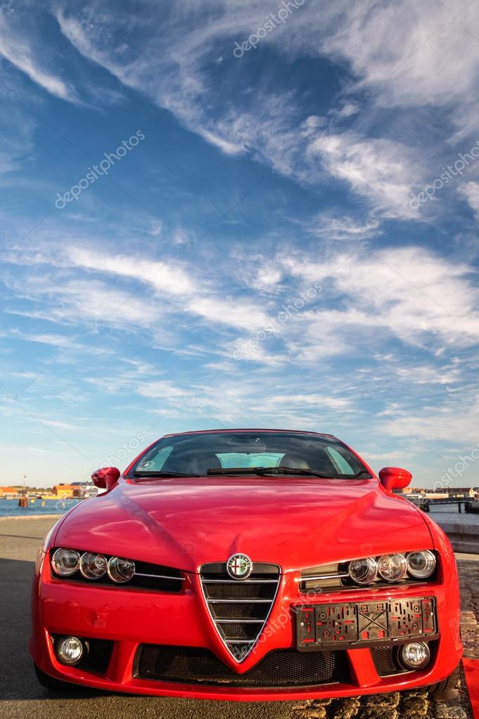 Red Alfa Romeo sports car (front view) with blue sky