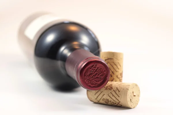 Corks and red wine bottle — Stock Photo, Image