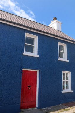 kırmızı bir kapı ile mavi boyalı evi