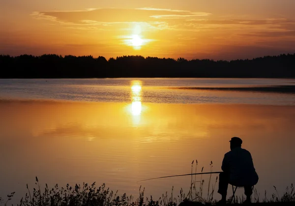 Fiskare siluett. Sunrise tidigt på morgonen. Stockbild