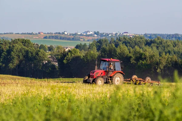 Açık bir günde traktör tarlayı sürüyor. Ufkun görünümü