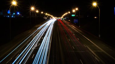 Gece trafiği. Büyük bir caddede araba ışıkları. Yukarıdan bak. beyaz ve kırmızı ışıklar, çizgiler.