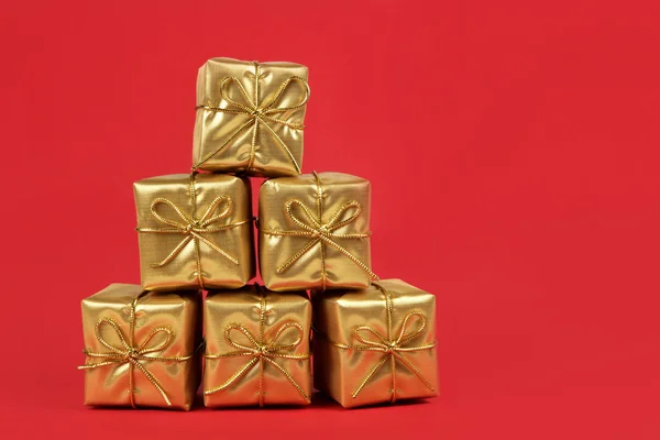 Gold Christmas presents on red background — Stock Photo, Image