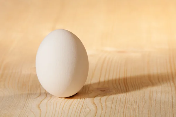 Ovo branco na mesa de madeira — Fotografia de Stock