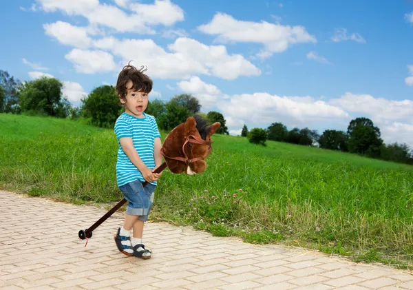 Ребенок играет с лошадиной палкой — стоковое фото