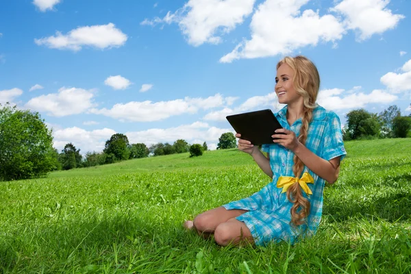 Student sitting on grass browsing — Stock Photo, Image