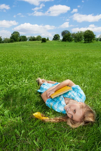 Smiling girl laying on lawn — Stock Photo, Image