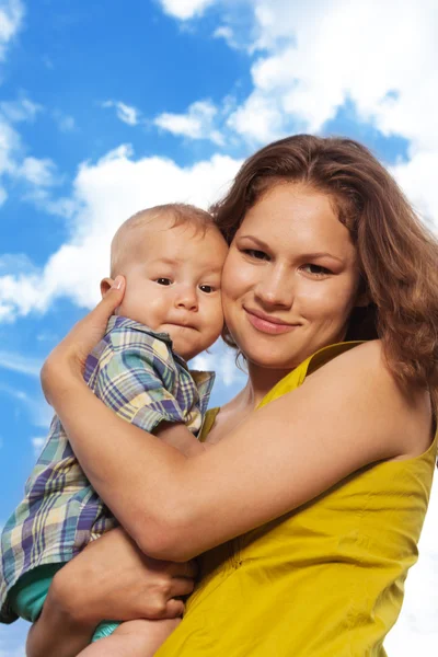 Happy mom and son on cloudy background — Stock Photo, Image