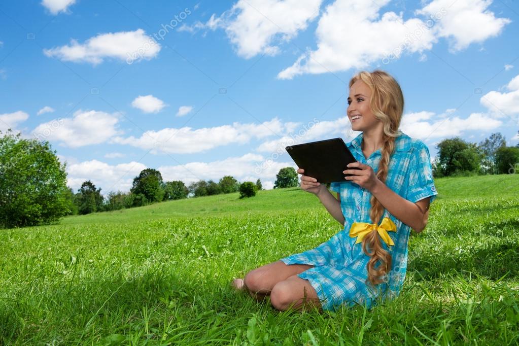 student sitting on grass browsing