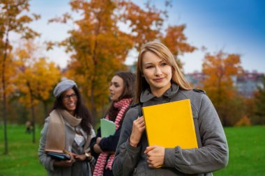 parkta kitaplar ile mutlu sarışın