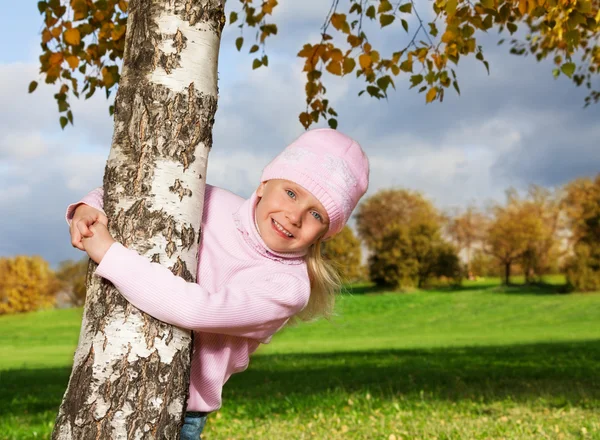 Mignonne petite fille étreignant arbre — Photo