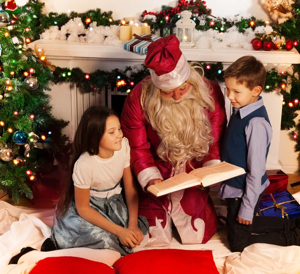 Papai Noel leitura livro de Natal para crianças — Fotografia de Stock