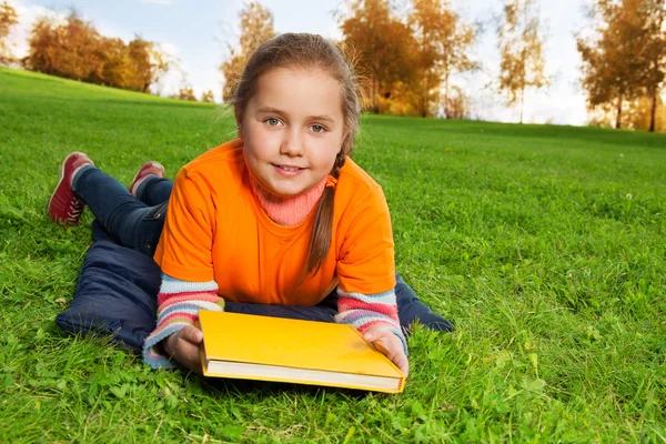 Mooie 8 jaar oud meisje in het park te leggen — Stockfoto