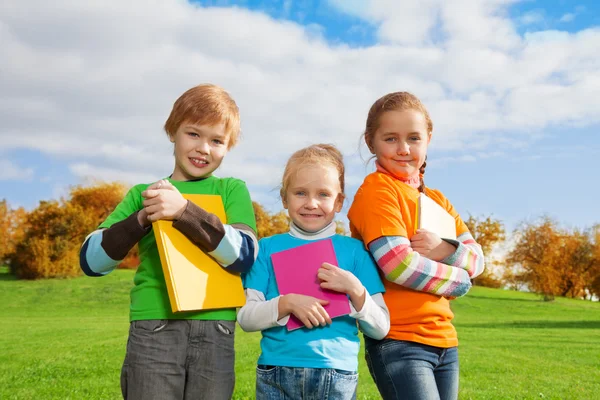 Tres niños con libros en el parque —  Fotos de Stock