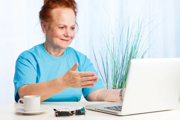 Senior lady pointing to the screen — Stock Photo, Image