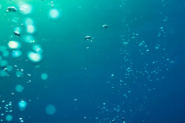 Luftblasen unter Wasser, die an die Oberfläche gelangen — Stockfoto