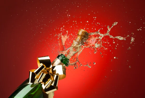 Cork popping from Champagne bottle with splashes — Stock Photo