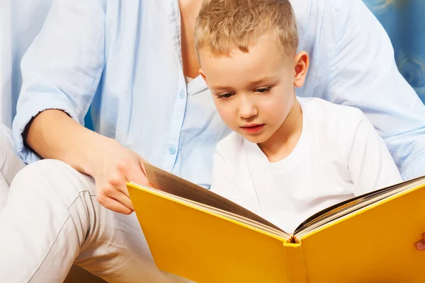 Lezen van een boek met moeders hulp — Stockfoto