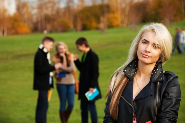 Jedna dziewczyna student z przyjaciółmi na tle — Zdjęcie stockowe