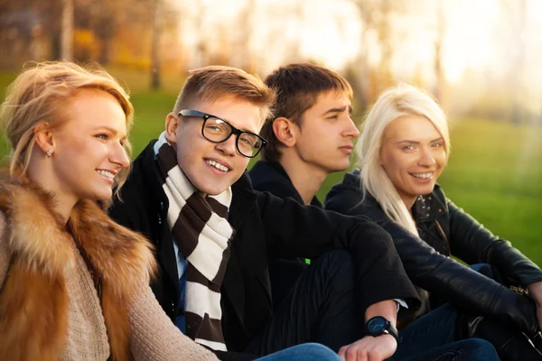 Vier Studenten sitzen im Park — Stockfoto