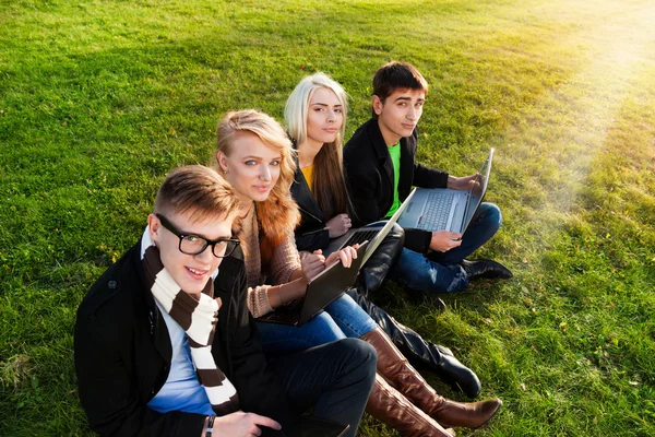 Čtyři studenti s notebookem — Stock fotografie