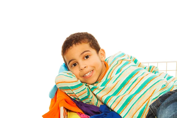 Feliz chico de piel oscura en la cesta de ropa —  Fotos de Stock