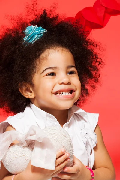 Pequena menina escura com coração de brinquedo — Fotografia de Stock