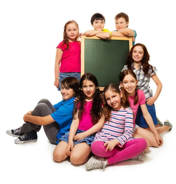 Large group of school kids and blackboard — Stockfoto