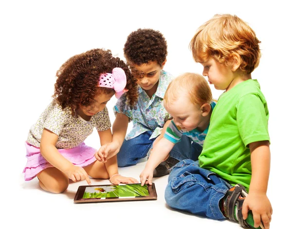 Cuatro niños jugando a la tableta — Foto de Stock