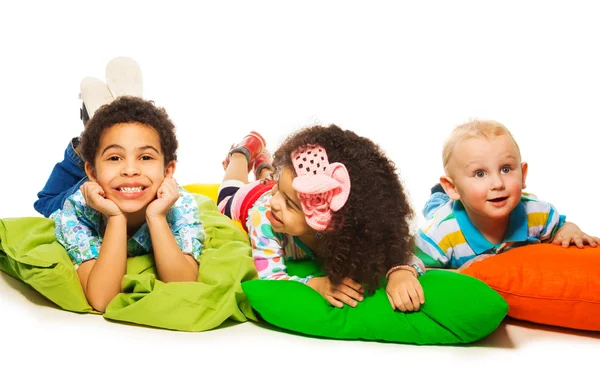 Tres niños felices en las almohadas —  Fotos de Stock