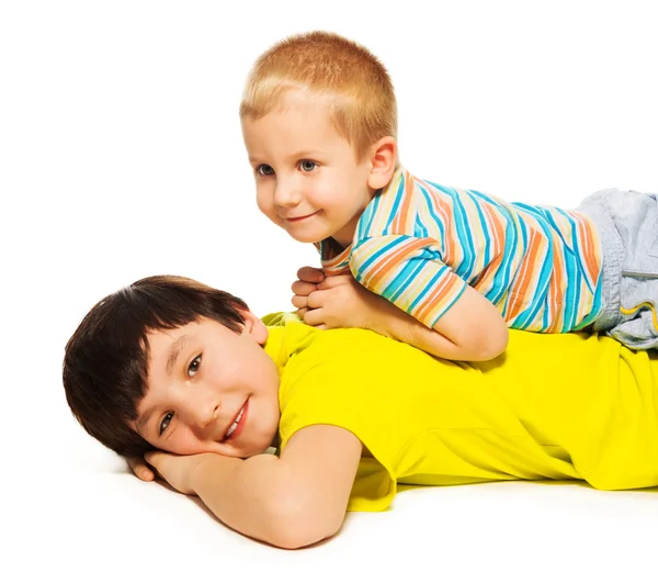 Young brother laying on the back of bigger — Stock Photo, Image