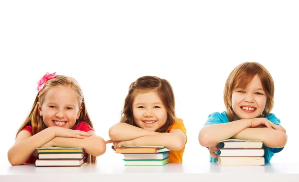 Drie slimme kinderen op stapel boeken — Stockfoto