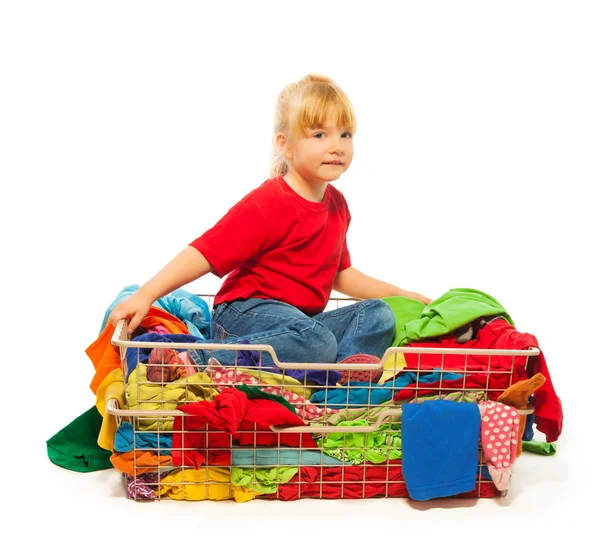 Blond girl sitting in the clothes basket Royalty Free Stock Photos