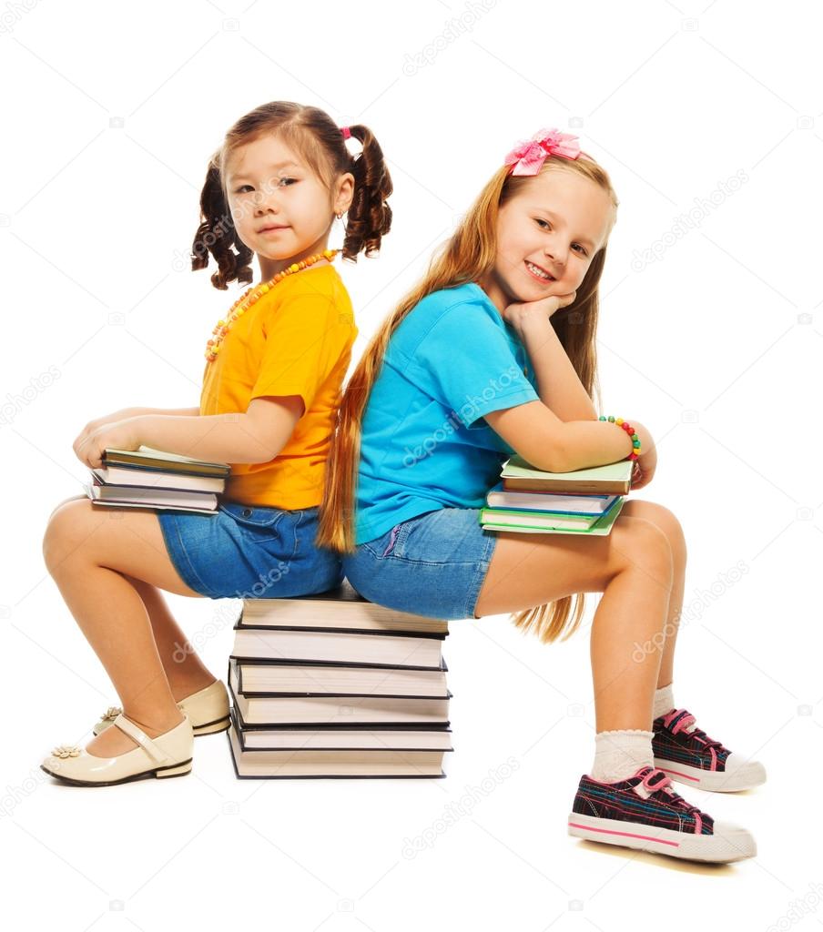 Two girls sitting on books