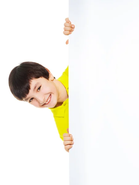 Caucasian boy looking from behind white board — Stock Photo, Image